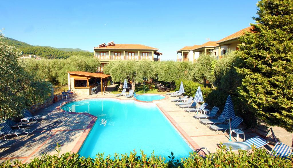 uma vista sobre uma piscina com cadeiras e uma casa em Hotel Thetis em Thásos
