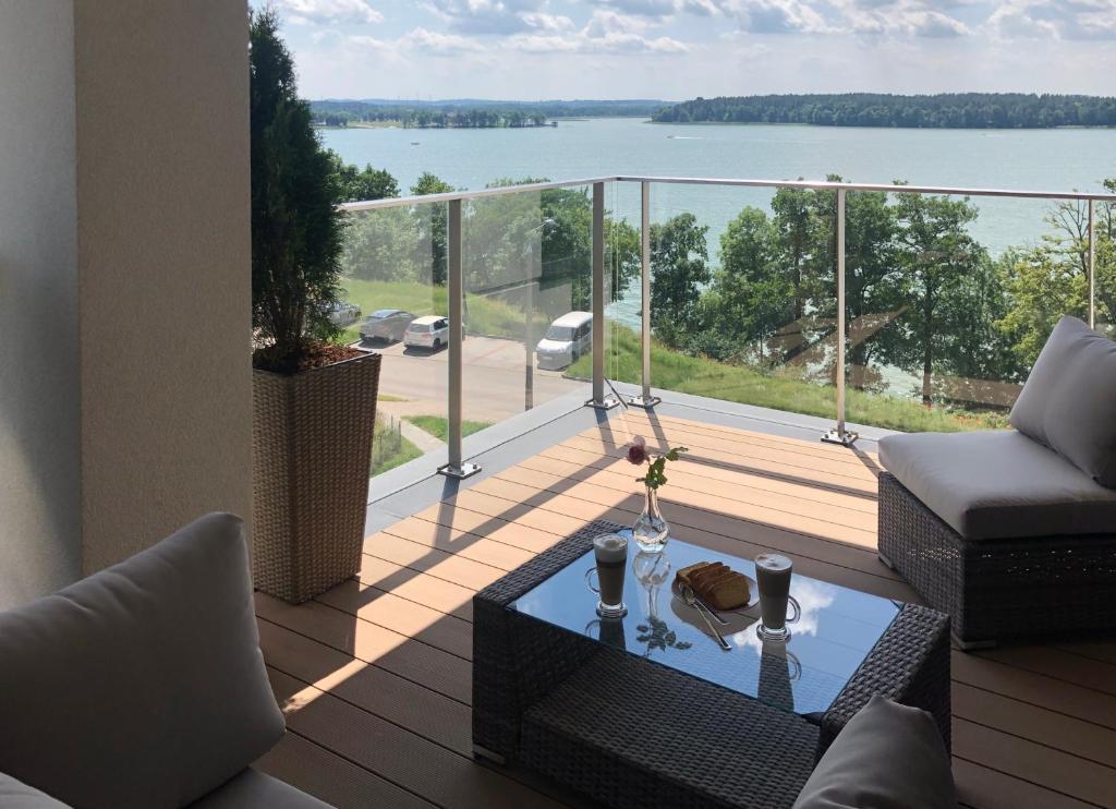 balkon ze stołem i widokiem na wodę w obiekcie Apartament Złota Brama w mieście Ełk