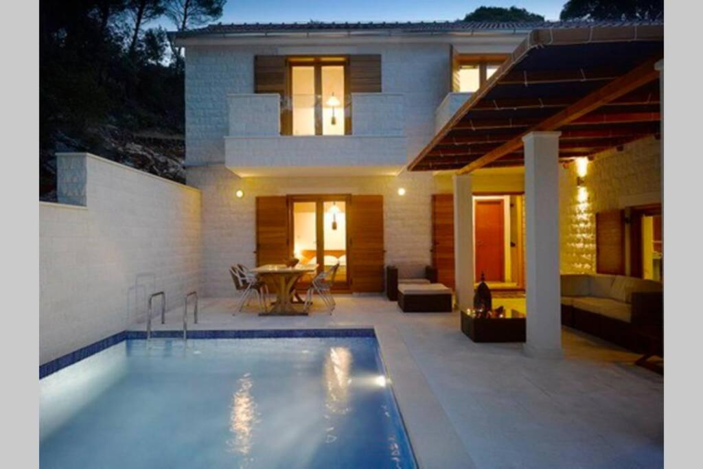 ein Haus mit einem Pool vor einem Haus in der Unterkunft Private luxury Villa AZZURRO on Solta for up to 10 persons, free parking, very close to beach! FREE Kajak & Mountainbikes, GREAT living area & privacy! in Rogač