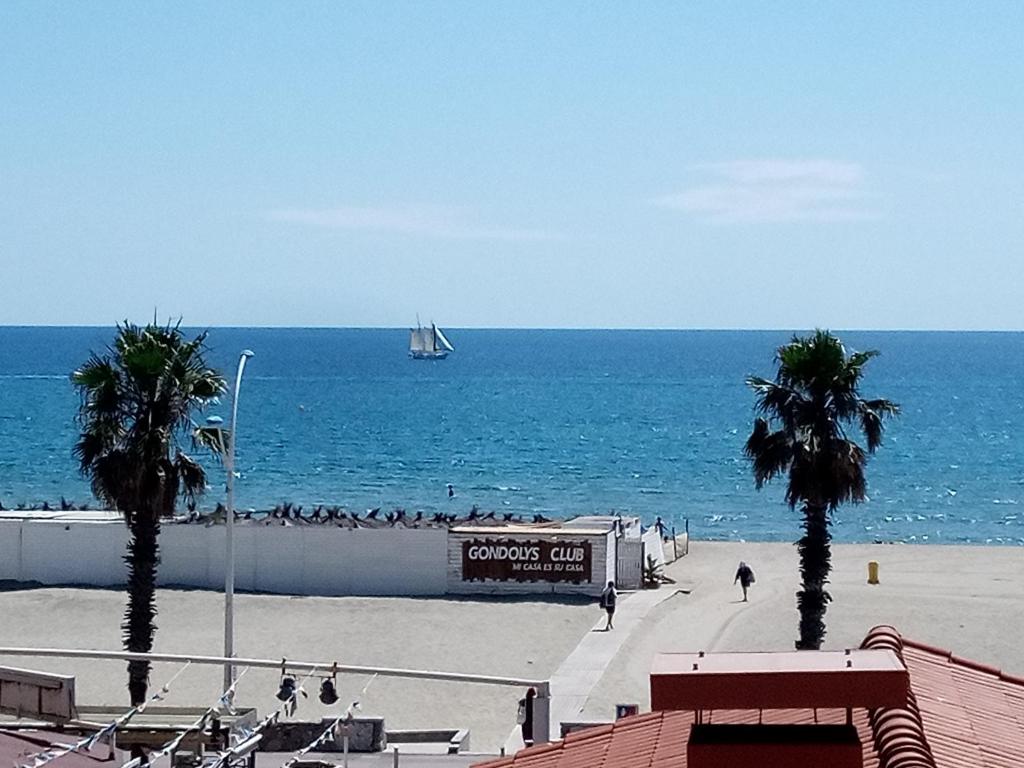 un velero en el océano con una playa en T3 Vue Mer Clim Wifi Parking, en Canet-en-Roussillon