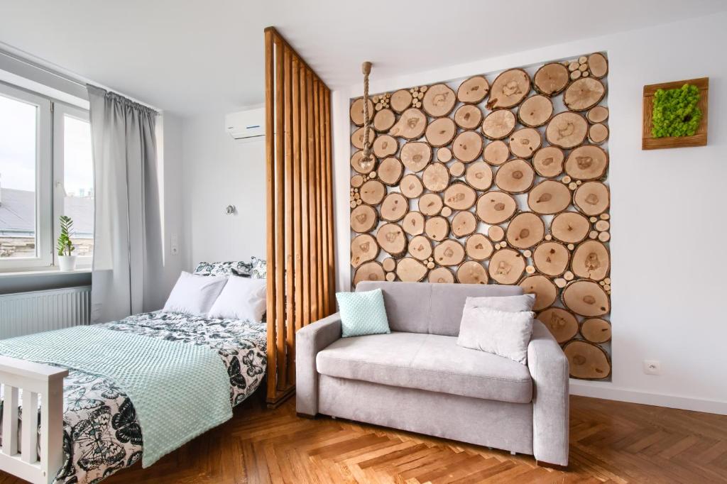 a bedroom with a logs wall next to a bed and a chair at Central Station Apartment - Wilcza in Warsaw