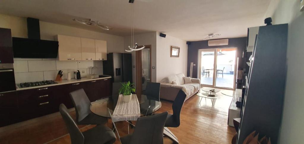 eine Küche und ein Wohnzimmer mit einem Tisch und Stühlen in der Unterkunft Apartmani Kvaternik - Stan Bol in Bol