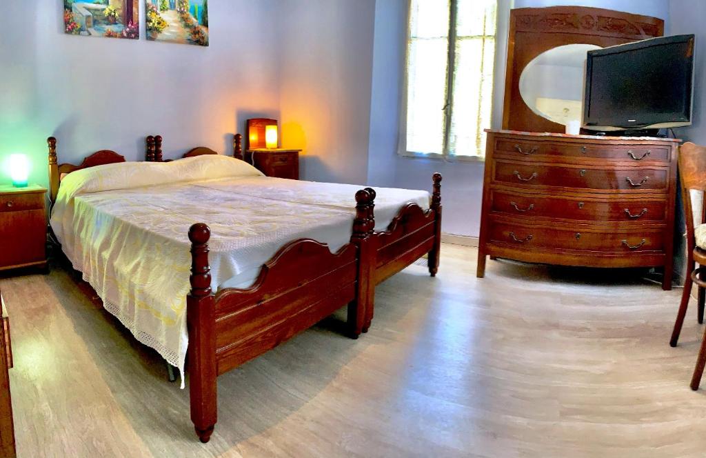 a bedroom with a bed and a dresser with a tv at casa la valle in San Fedele Intelvi