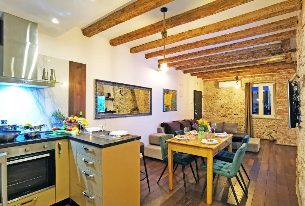 een keuken en een woonkamer met een tafel en een eetkamer bij Pearl Stone Apartments in Šibenik