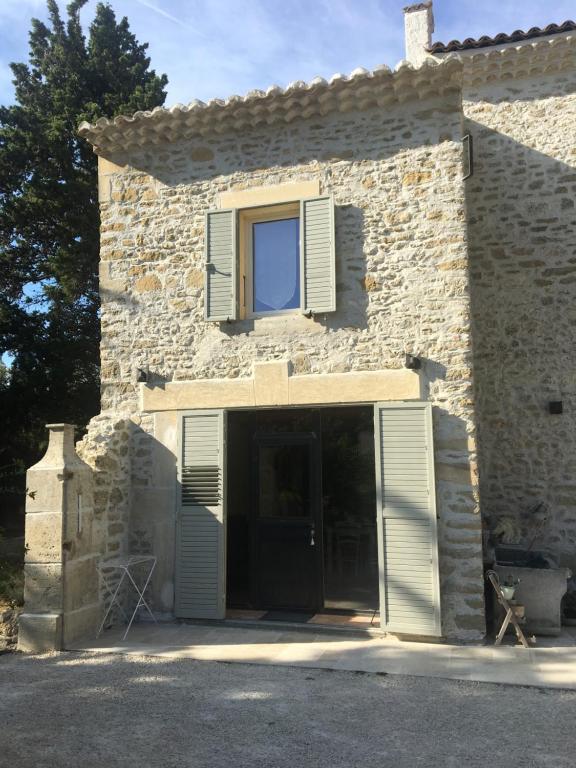 une maison en pierre avec une porte et une fenêtre dans l'établissement gite la magnanerie, à Réauville
