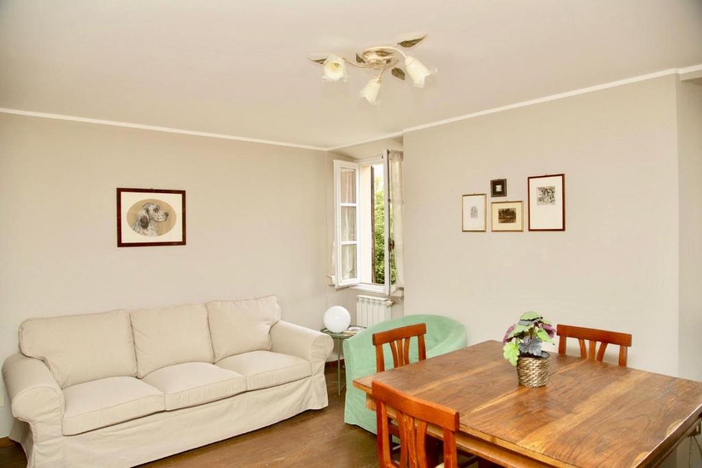 uma sala de estar com um sofá branco e uma mesa em Contempora Apartments - Ca' Brenta Patriot em San Fedele Intelvi