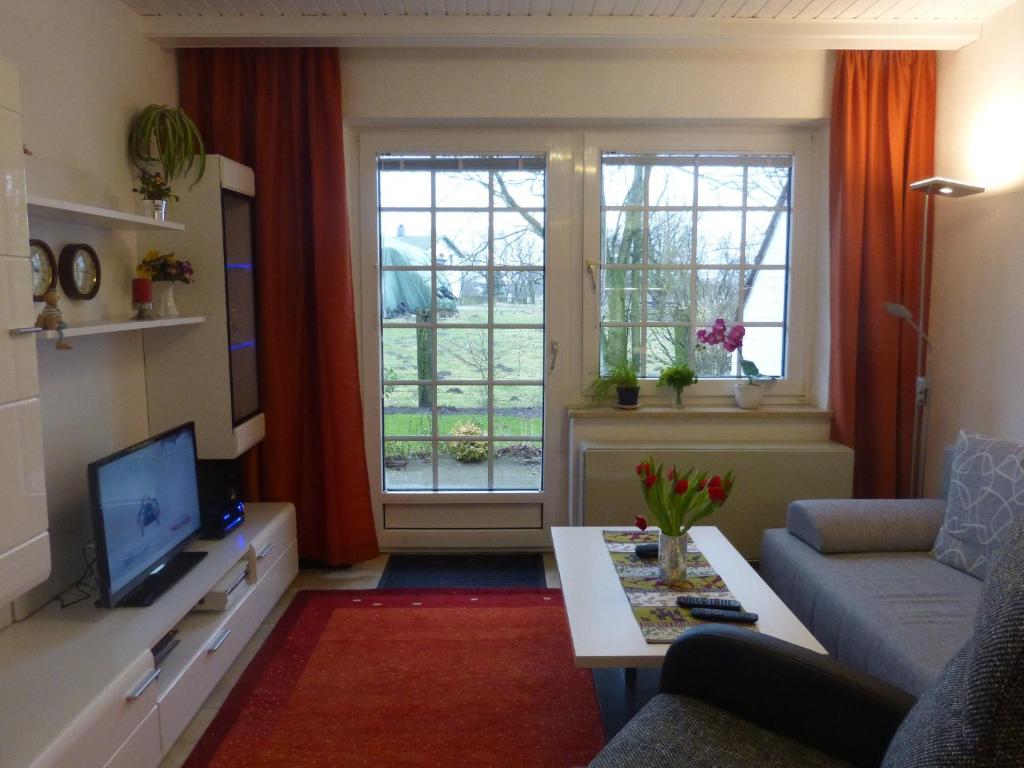 uma sala de estar com um sofá e uma televisão em Fewo-Nordseestrand em Büsum