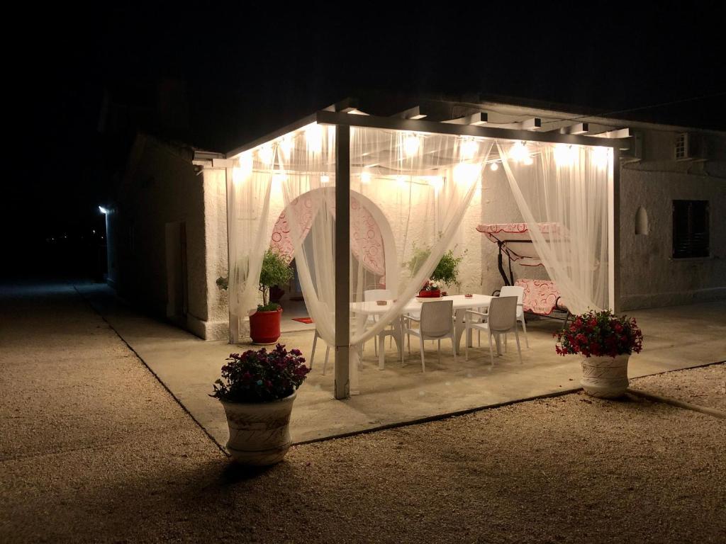 a gazebo with a table and chairs in it at night at Villa Cenzina in Marina di Pisticci