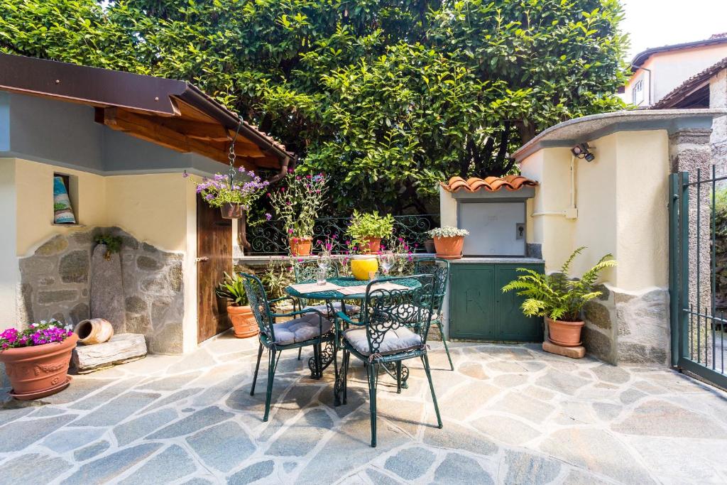 een patio met een tafel en stoelen en potplanten bij il Cortiletto in Stresa