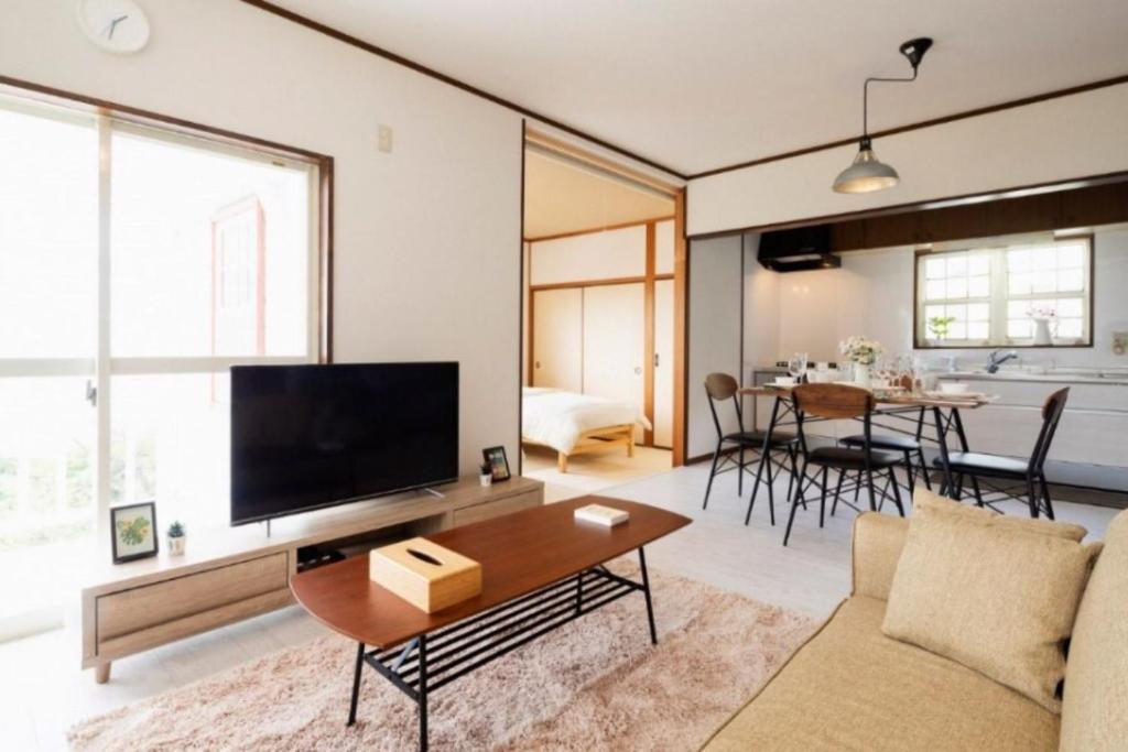 ein Wohnzimmer mit einem Sofa und einem TV in der Unterkunft ANJIN STAY AWAJI - Vacation STAY 83766 in Awaji