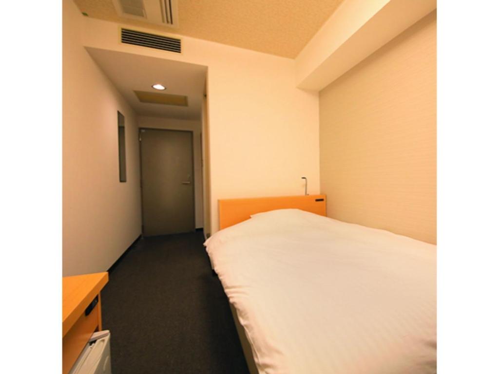Habitación pequeña con cama y escritorio. en HOTEL SUN OCEAN - Vacation STAY 84237, en Anan
