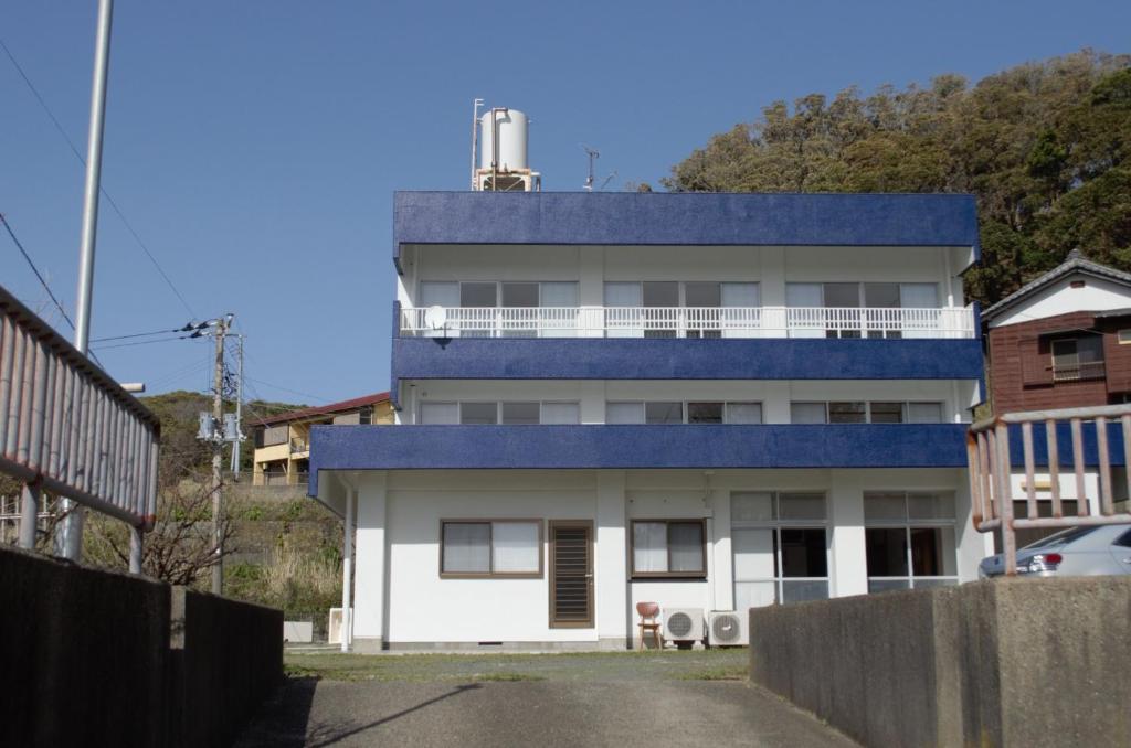 胜浦市Amami - Vacation STAY 83858的白色的建筑,带有蓝色的屋顶,设有阳台