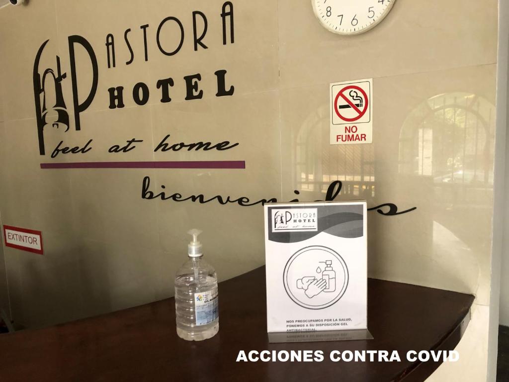 una botella de agua sentada en una mesa junto a un cartel en Hotel Pastora, en Córdoba