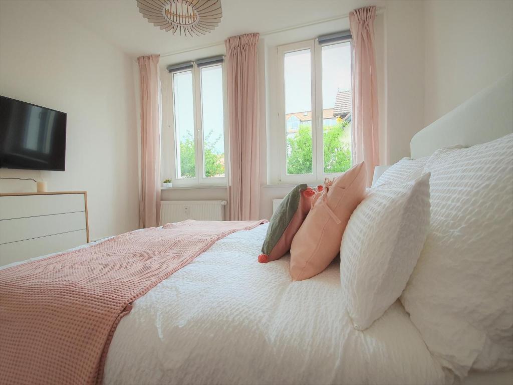 a person laying on a bed with pillows at PB Ferienwohnungen - FeWo 2 - Stilvoll eingerichtetes Apartment im Herzen Senftenbergs in Senftenberg