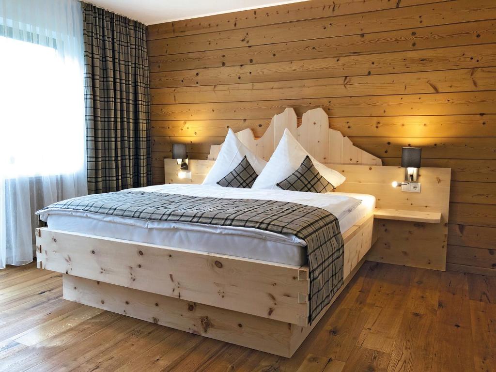 タンハイムにあるFerienwohnungen Meusburgerの木製の壁に大きなベッドが備わるベッドルーム1室
