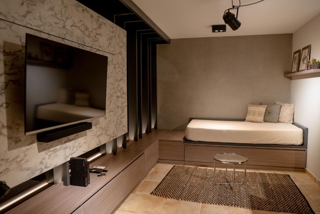 a bedroom with a bed and a tv on a wall at DOMUS APART in Río Cuarto
