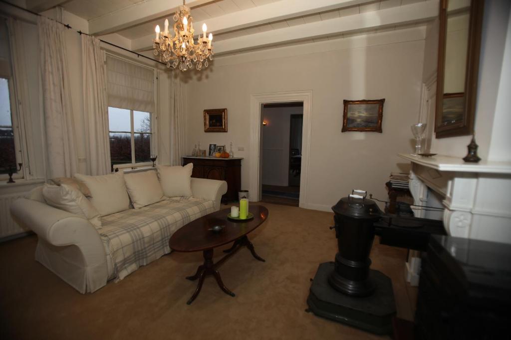 ein Wohnzimmer mit einem Sofa und einem Tisch in der Unterkunft B&B Snellenstein in Neerijnen
