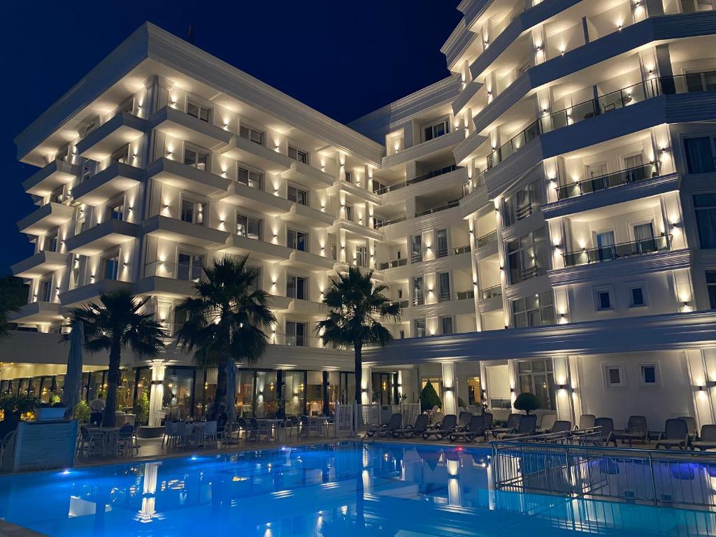 a hotel with a swimming pool in front of a building at Klajdi Resort & SPA in Golem