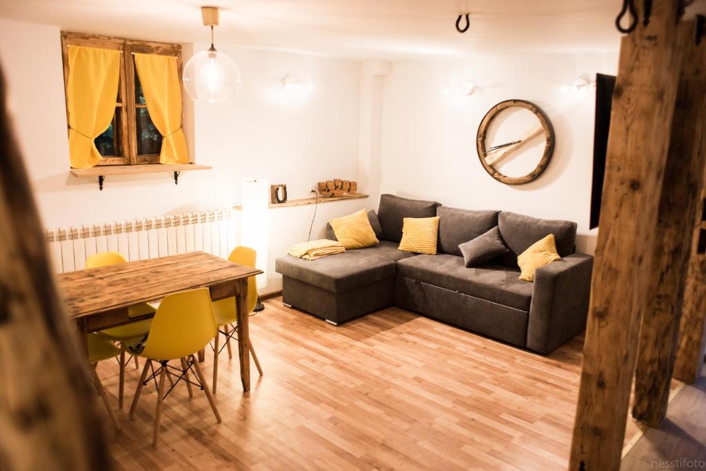 ein Wohnzimmer mit einem Sofa und einem Tisch in der Unterkunft Apartamenty u Janka in Krynica-Zdrój