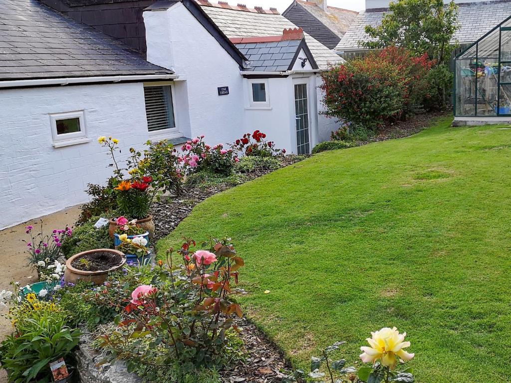 a garden with flowers in the yard of a house at Cove Cottage in Tintagel