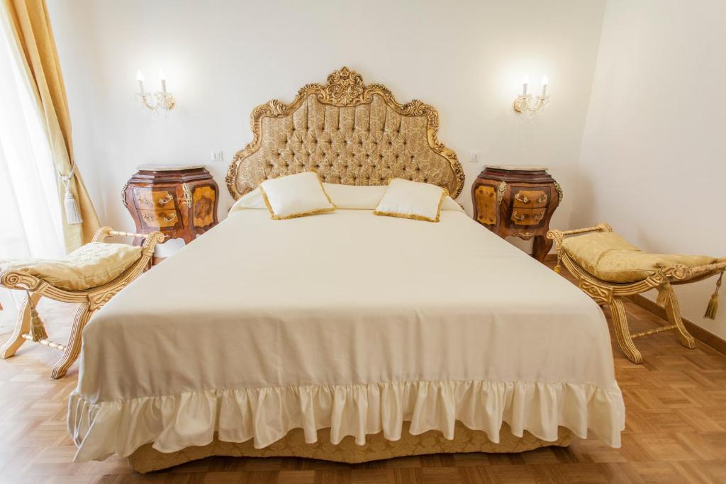 1 Schlafzimmer mit einem großen Bett und 2 Stühlen in der Unterkunft Suite Sarandrea in Rom