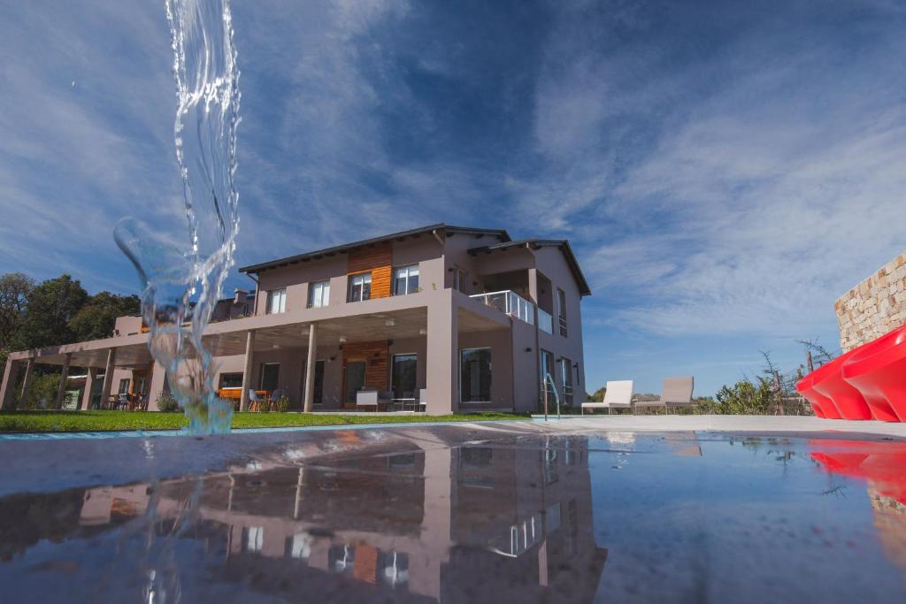 a house with a fountain in front of a building at Amalinas Hotel in San Lorenzo