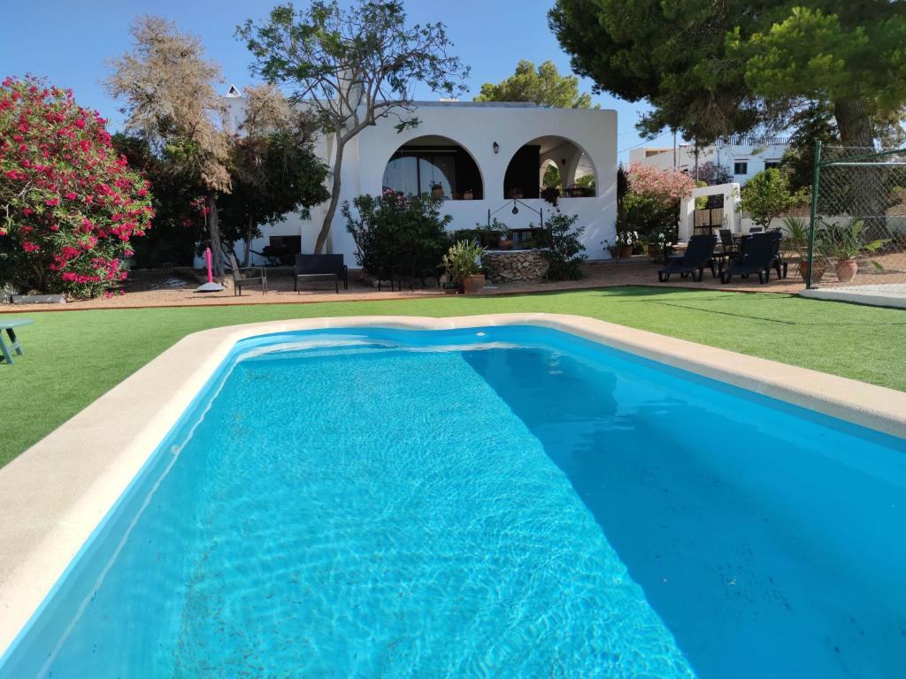 a swimming pool in front of a house at Beach and Tennis in Sant Josep de Sa Talaia