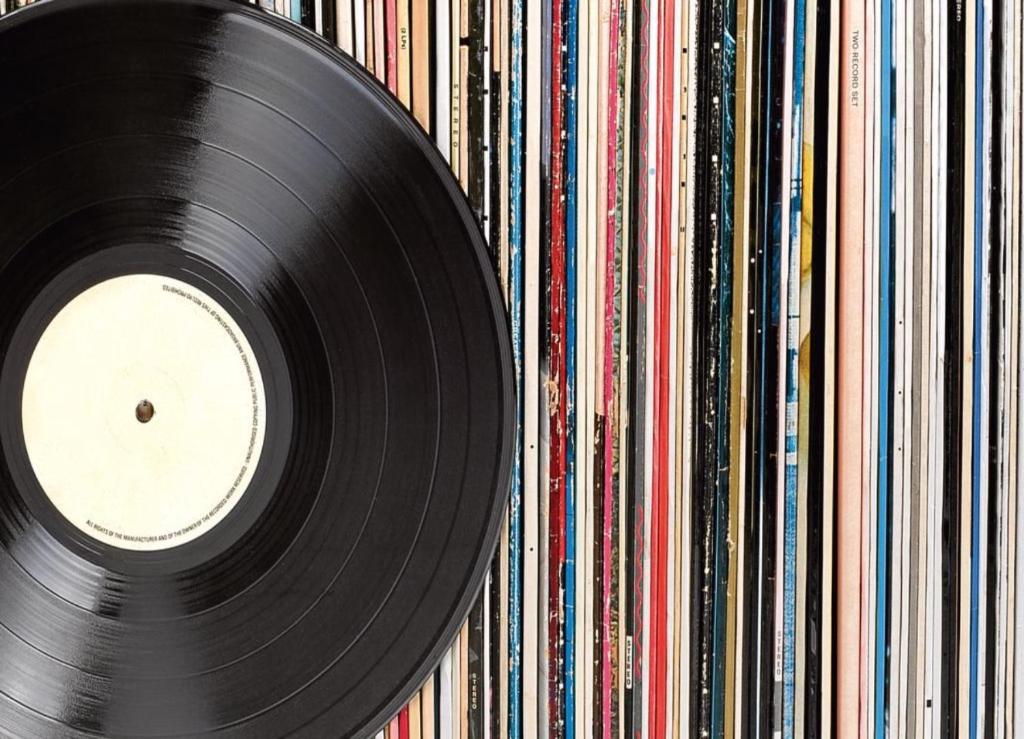 a vinyl record is sitting on a wall of albums at Vinyl’s Place in Braşov