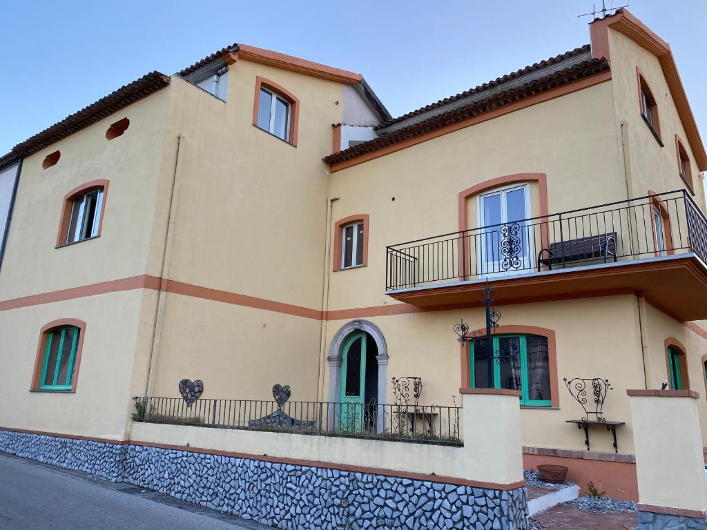 un grand bâtiment jaune avec balcon dans une rue dans l'établissement La Casa di Michele, à Trecchina