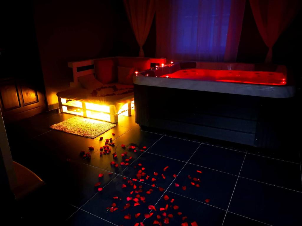 Habitación con bañera con luces rojas en el suelo en Zöld Sziget Wellness en Egerszalók