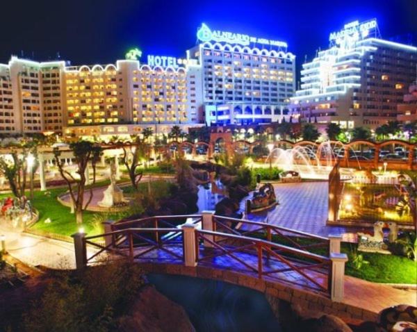 uma cidade à noite com uma ponte e edifícios em Costa Caribe III em Oropesa del Mar