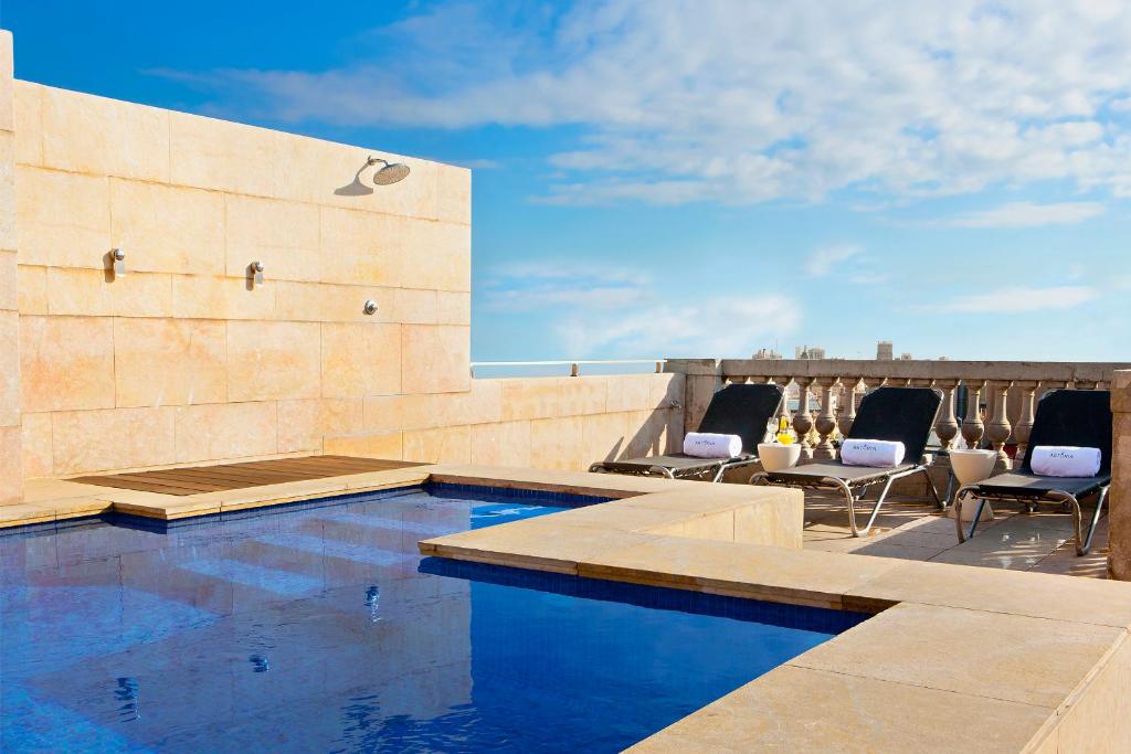 a swimming pool on the roof of a house at Hotel Astoria in Barcelona