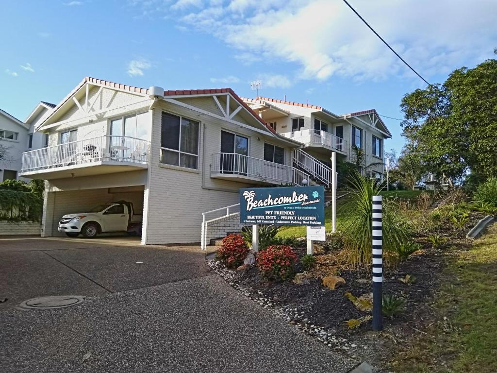 uma casa com um sinal em frente em Beachcomber - Pet Friendly em Merimbula