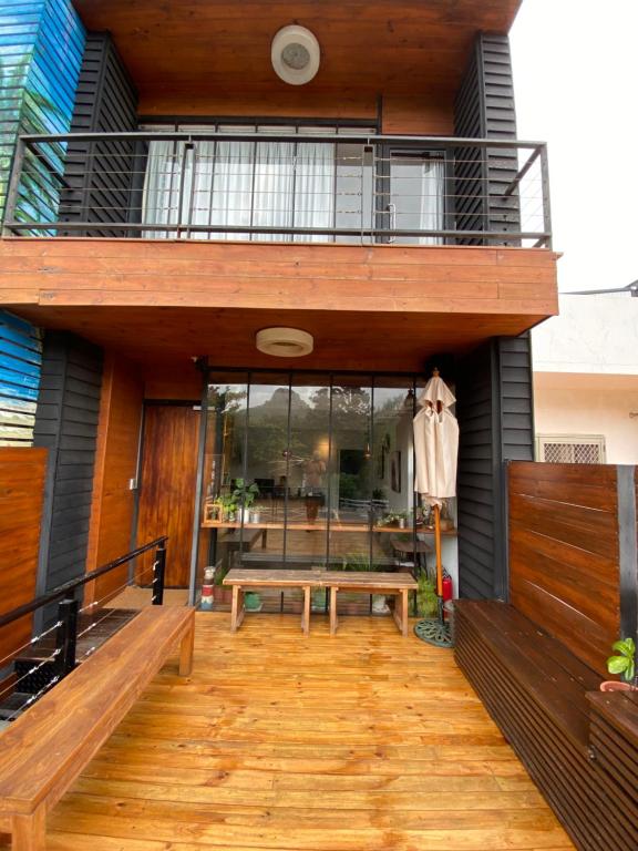 a house with a deck with a bench and a balcony at Playful House in Kenting