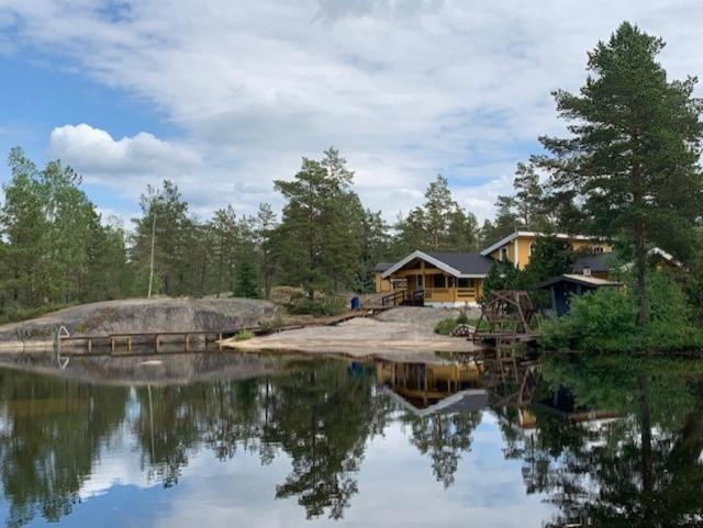 a house on the shore of a body of water at Luxury Holiday Home with Private Lake in Vehmaa