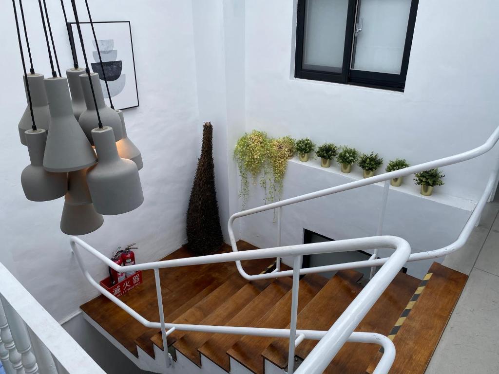 a staircase with a white rail and some plants at Playful House in Kenting