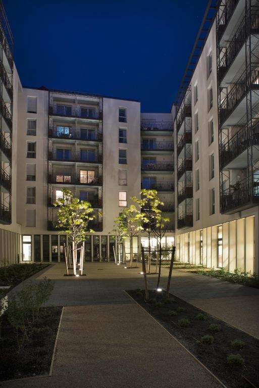un grand bâtiment avec des arbres devant dans l'établissement Domitys Le Pont des Lumières, à Lyon