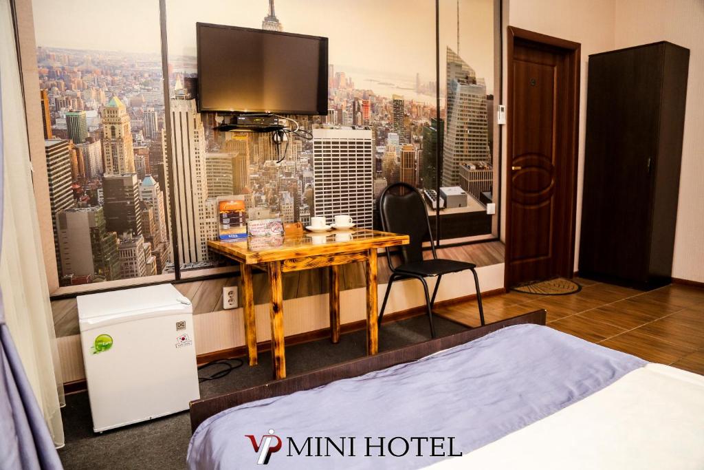 a hotel room with a desk and a large window at VIP Mini Hotel in Semey