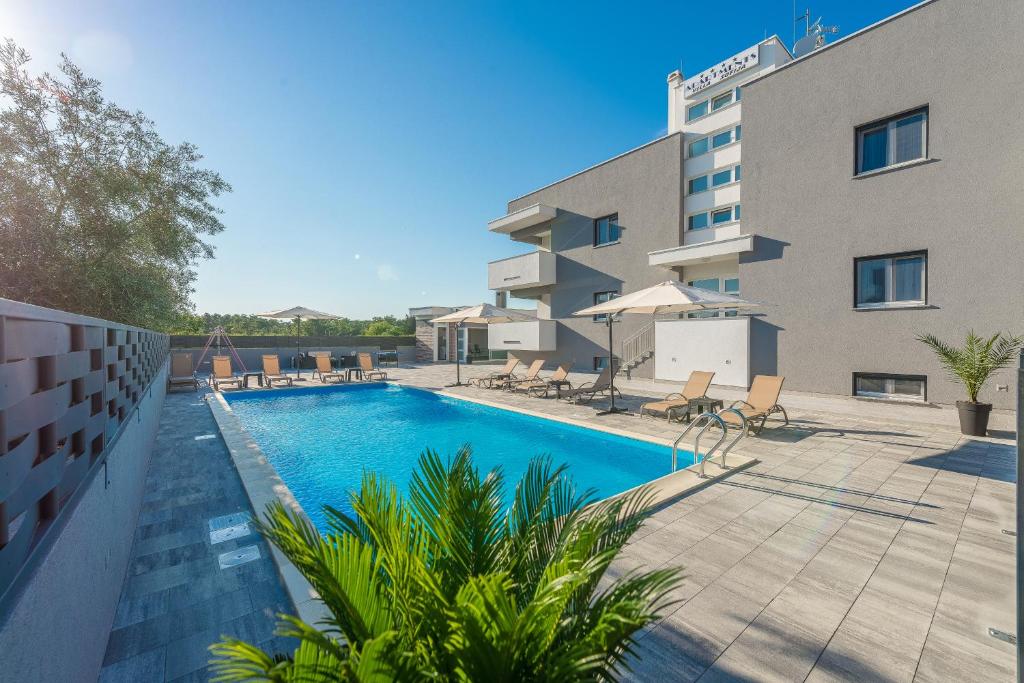 a swimming pool in front of a building at VILLA SOFIJA in Zaton