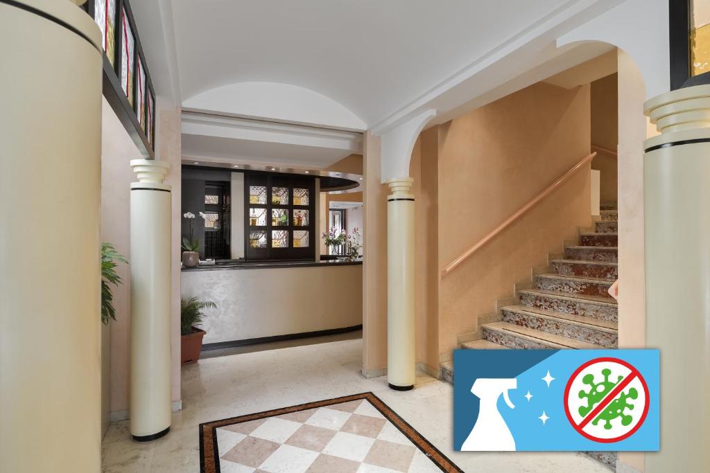 un vestíbulo con una escalera y un cartel que dice que no se puede fumar en Hotel Garibaldi en Mestre