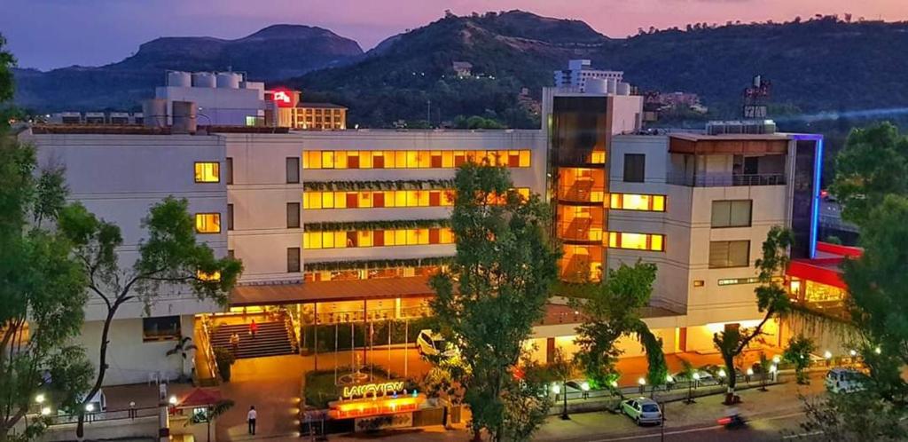 a building with lights on in a city at night at Hotel Lake View in Saputara