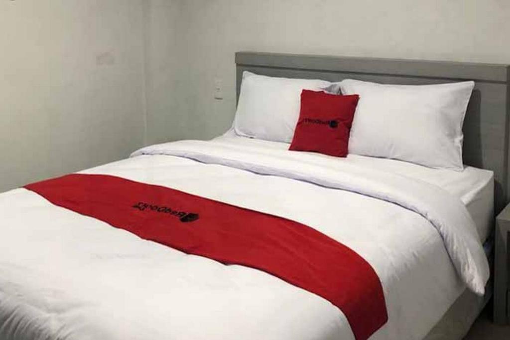 a red and white bed with two pillows on it at RedDoorz near RS USU Medan 3 in Medan