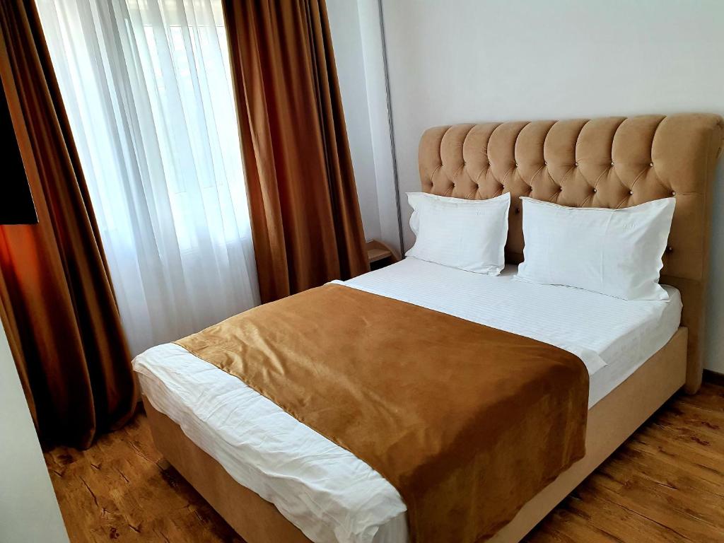 1 dormitorio con 1 cama grande y ventana grande en Laura Apartments Sinaia, en Sinaia