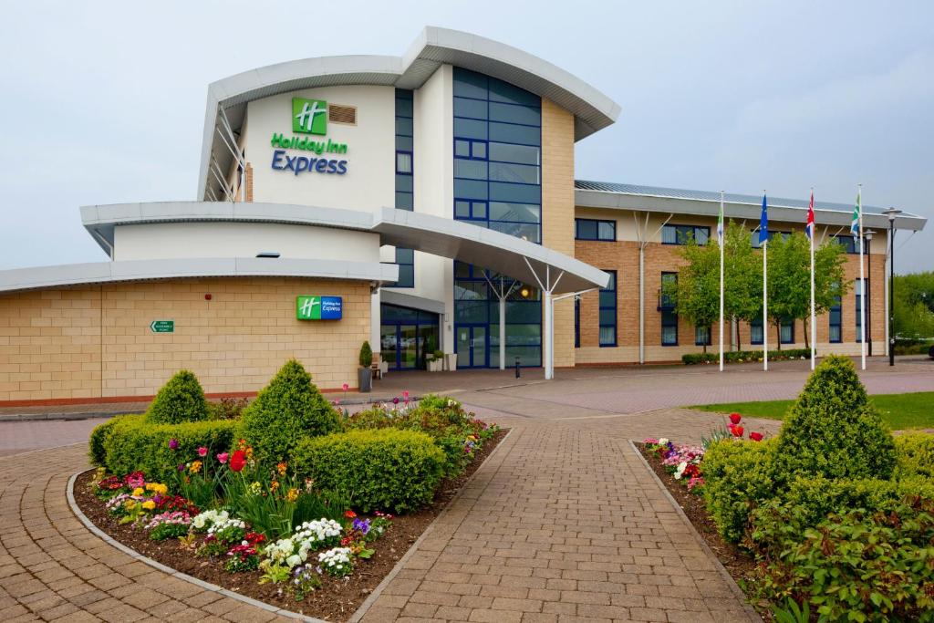 un hospital con flores frente a un edificio en Holiday Inn Express Northampton - South, an IHG Hotel en Northampton