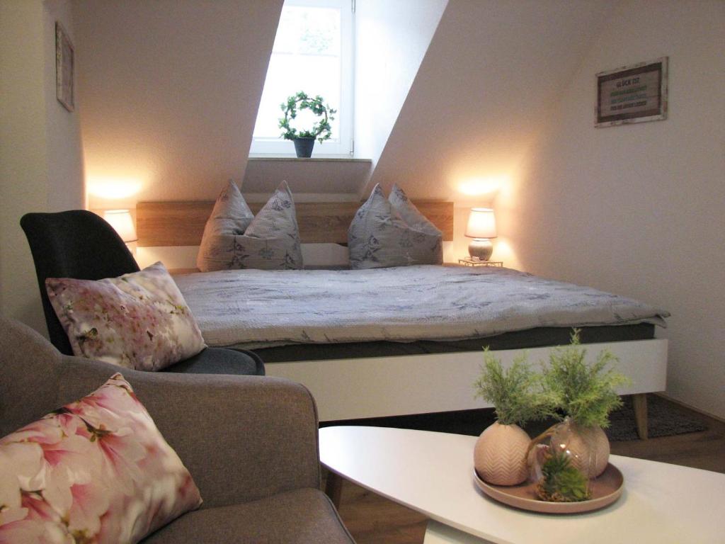 ein Schlafzimmer mit einem Bett, einem Sofa und einem Tisch in der Unterkunft Ferienzimmer Zentrum in Bad Schandau
