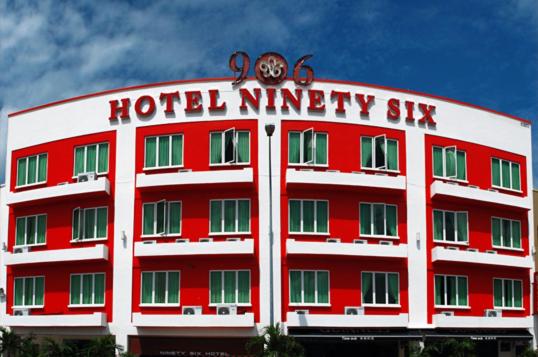 ein rotes Hotel, 96 Gebäude mit einer Uhr oben in der Unterkunft 906 Hotel Melaka Raya in Malakka
