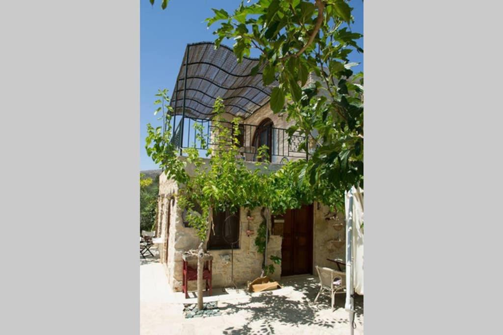 une ancienne maison en pierre avec un toit en gambrel dans l'établissement Petite Olive House, à Siteía