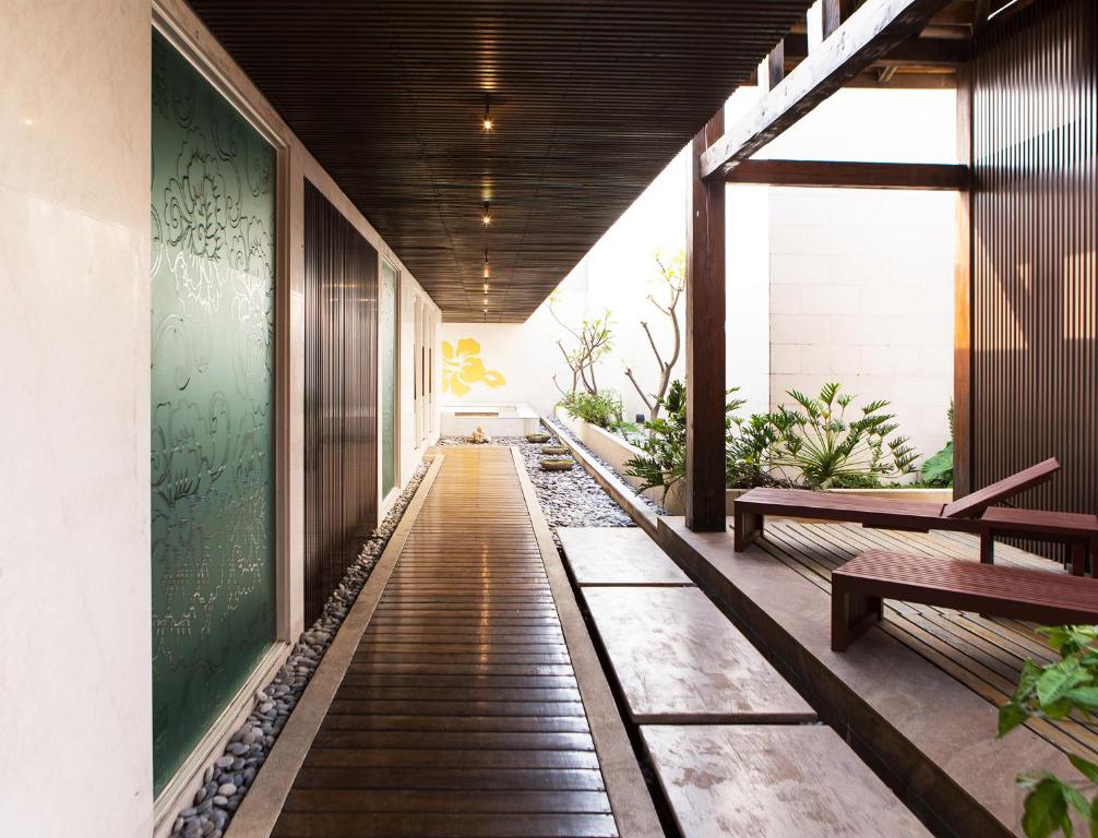 a corridor of a building with benches and plants at All-Ur Boutique Motel - KaoHsiung Branch in Kaohsiung