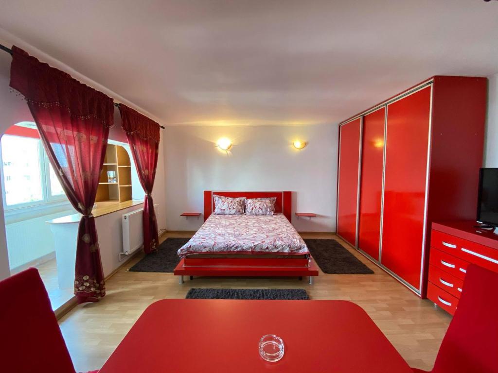 a bedroom with a red bed and a red cabinet at Faleză nord in Constanţa
