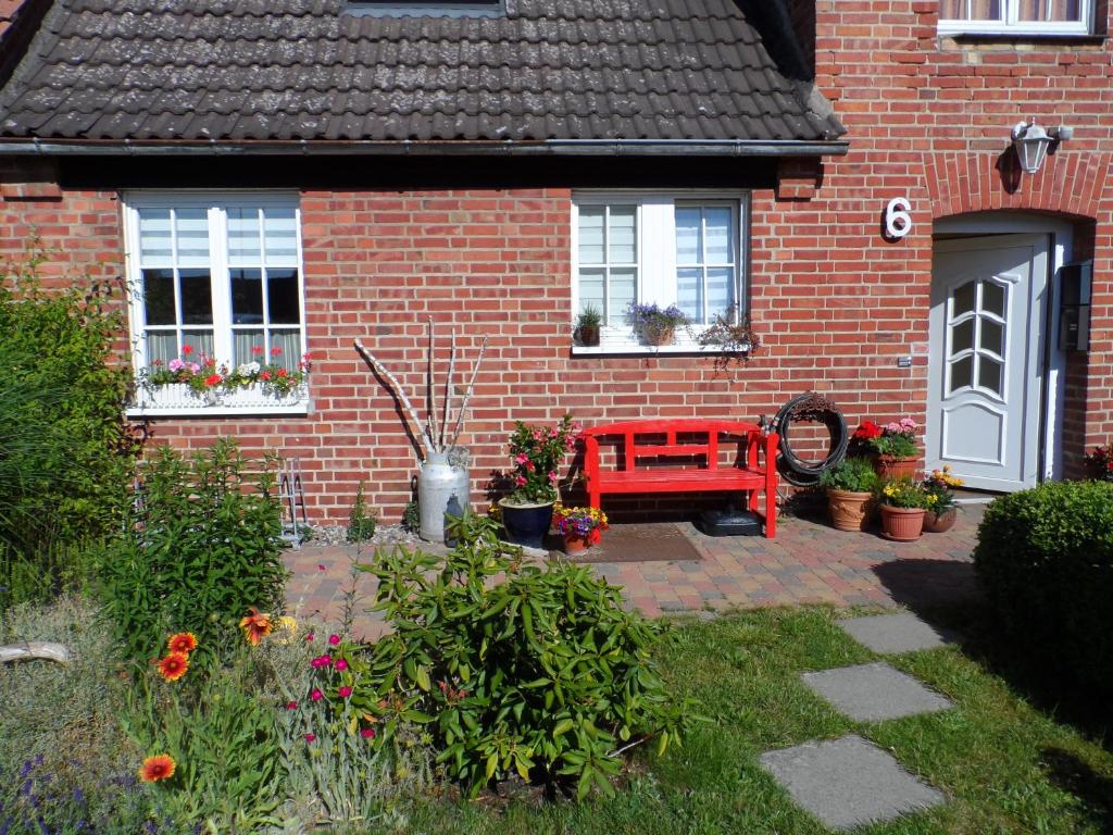 a red bench in front of a brick house at Lütt Verbliev in Malchow
